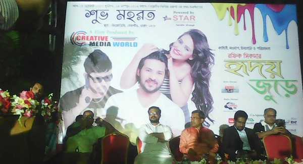 মহরত অনুষ্ঠানে বক্তব্য রাখছেন পরিচালক রফিক শিকদার। পাশে মঞ্চে উপবিষ্ট অতিথিরা।