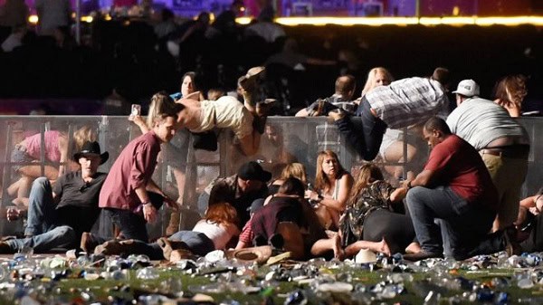 Las Vegas shooting aftermath with people gathering and debris on the ground. Channel i News - চ্যানেল আই নিউজ