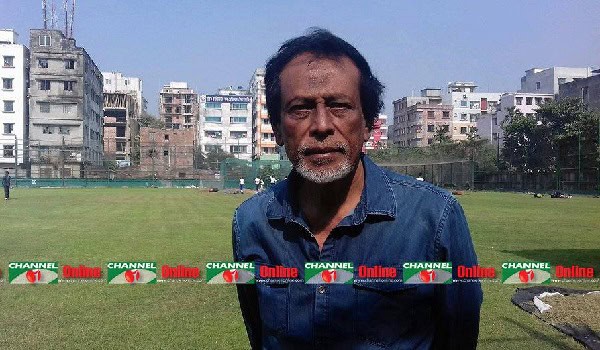 বৃদ্ধ ব্যক্তি মাঠে দাঁড়িয়ে, শহরের পটভূমিতে।. Channel i News - চ্যানেল আই নিউজ