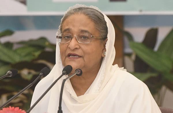 প্রধানমন্ত্রী ভাষণ দিচ্ছেন, পেছনে সবুজ গাছের পাতা. Channel i News - চ্যানেল আই নিউজ