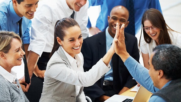 Beautiful business woman high fiving colleague during meeting