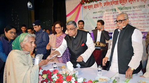 Elderly woman receiving award from dignitaries at a formal event in Bangladesh. Channel i News - চ্যানেল আই নিউজ