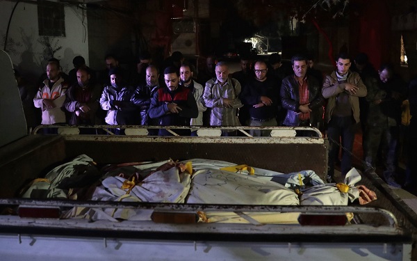 দৌমা শহরে একটি অস্থায়ী মর্গের বাইরে পিকআপ ট্রাকের পেছনে রাখা নিহতদের জন্য প্রার্থনা, ২০১৭ সালের ছবি 