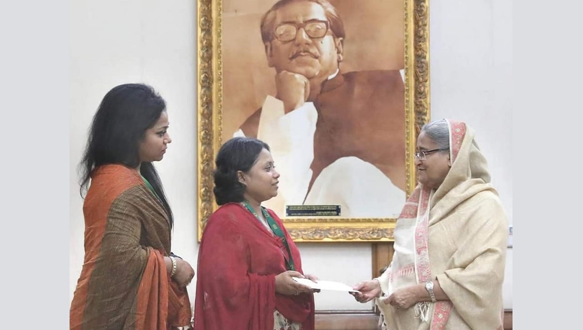 প্রধানমন্ত্রীর হাত থেকে অনুদান নিচ্ছেন পলি সায়ন্তনী। তার পাশে ডলি সায়ন্তনী