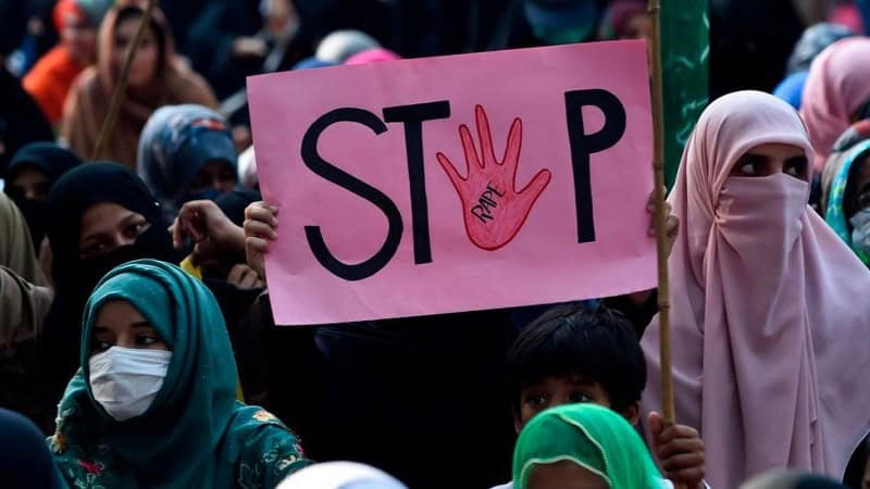 প্রতিবাদী নারীরা 'স্টপ' লেখা প্ল্যাকার্ড ধরে প্রতিবাদ করছে. Channel i News - চ্যানেল আই নিউজ