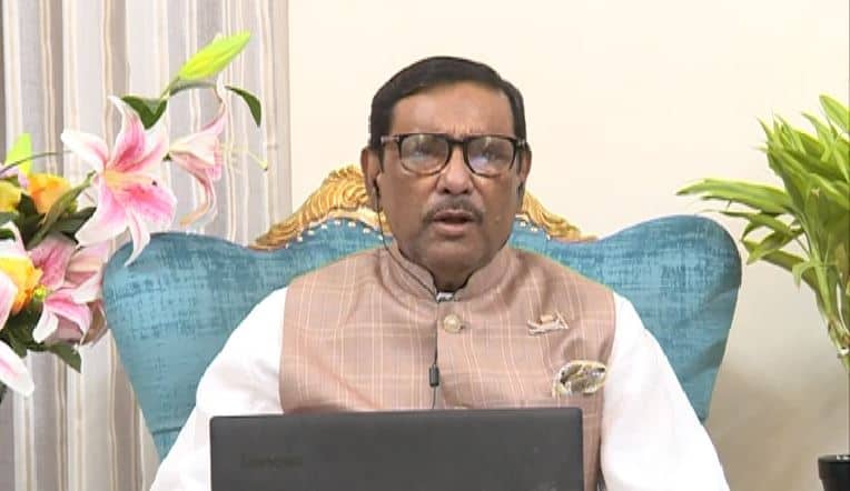 কাদেরের বক্তব্যের ছবি, তিনি একটি টেবিলের সামনে বসে আছেন. Channel i News - চ্যানেল আই নিউজ