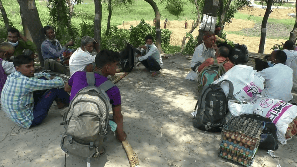 জনপ্রত্যাশী মানুষ গন্তব্যের অপেক্ষায় মহাসড়কের পাশে বসে।. Channel i News - চ্যানেল আই নিউজ