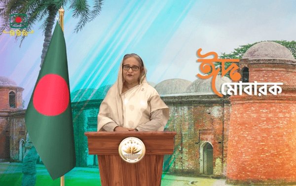 প্রধানমন্ত্রী জাতীয় স্মারক স্থানে ভাষণ দিচ্ছেন, বাংলাদেশ পতাকা পাশে।. Channel i News - চ্যানেল আই নিউজ