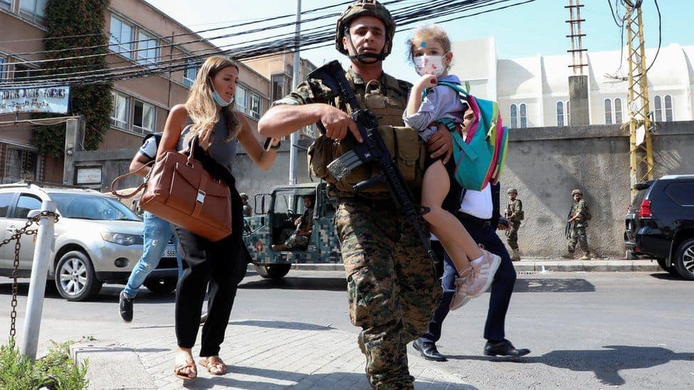 Lebanese soldier with a child during a protest amid conflict. Channel i News - চ্যানেল আই নিউজ