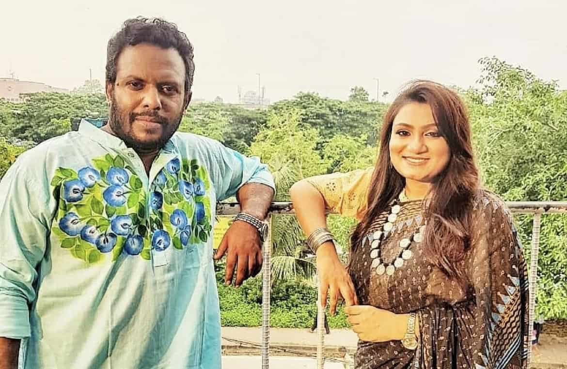 দুই মানুষ হাস্যোজ্জ্বলভাবে ছবি তুলছেন, প্রকৃতি পেছনে. Channel i News - চ্যানেল আই নিউজ
