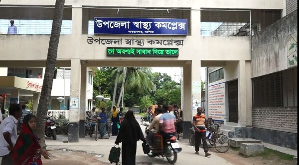 উপজেলা স্বাস্থ্য কমপ্লেক্সের প্রবেশদ্বার, জনসমাগম ও বাইসাইকেল ও মোটরসাইকেল পার্কিং. Channel i News - চ্যানেল আই নিউজ