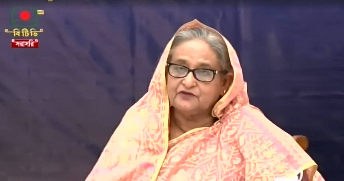 প্রধানমন্ত্রী শেখ হাসিনা ভাষণ দিচ্ছেন, পটভূমিতে বাংলাদেশী পতাকা. Channel i News - চ্যানেল আই নিউজ
