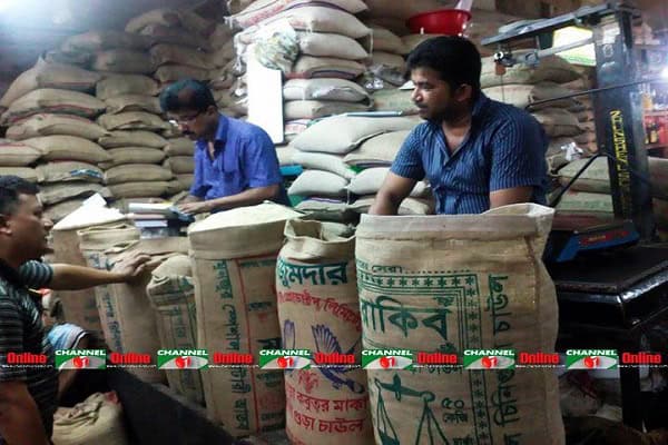ব্যবসায়ীরা চালের গুদামে পণ্য পরিমাপ ও বিক্রয় করছেন. Channel i News - চ্যানেল আই নিউজ