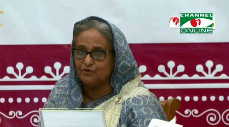 প্রধানমন্ত্রী বইমেলা উদ্বোধন করছেন, পেছনে চ্যানেল আই অনলাইন লোগো. Channel i News - চ্যানেল আই নিউজ