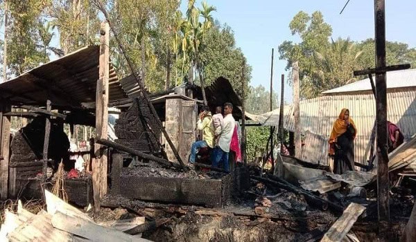 Burnt remains of a house with people inspecting the damage in Bangladesh. Channel i News - চ্যানেল আই নিউজ