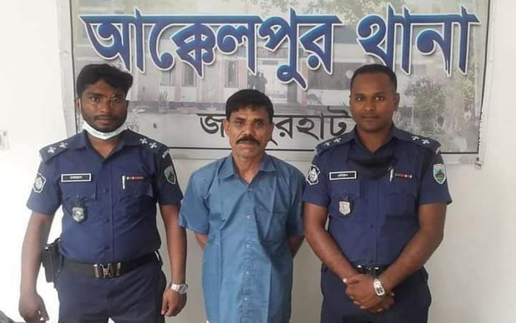 জালাল সরদারকে গ্রেপ্তার দেখানো হচ্ছে, পুলিশ সদস্যরা পাশে দাঁড়িয়ে. Channel i News - চ্যানেল আই নিউজ
