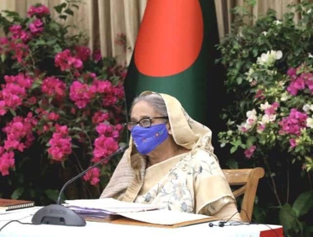 প্রধানমন্ত্রী শেখ হাসিনা বৈঠকে বসে, মুখে মাস্ক পরা, ফুলের বাগানে. Channel i News - চ্যানেল আই নিউজ
