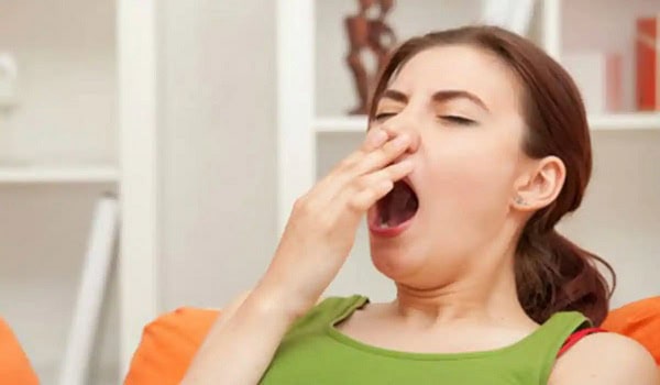 Women yawning and stretching at home, feeling sleepy after lunch. Channel i News - চ্যানেল আই নিউজ