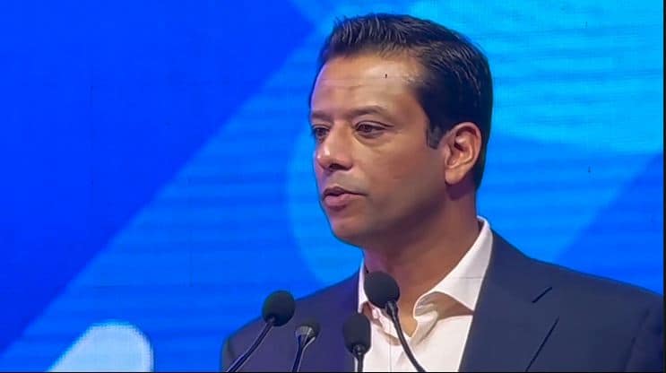 সজীব ওয়াজেদ জয় বক্তৃতা দিচ্ছেন, পেছনে বাংলা ও আন্তর্জাতিক পতাকা. Channel i News - চ্যানেল আই নিউজ