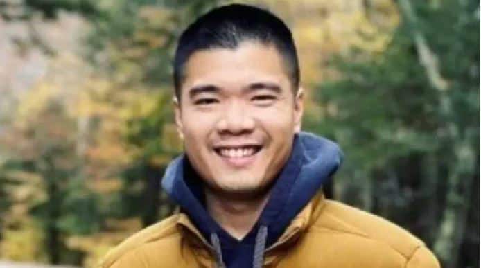 খুশি যুবক outdoors in autumn setting, wearing a yellow jacket and blue hoodie. Channel i News - চ্যানেল আই নিউজ