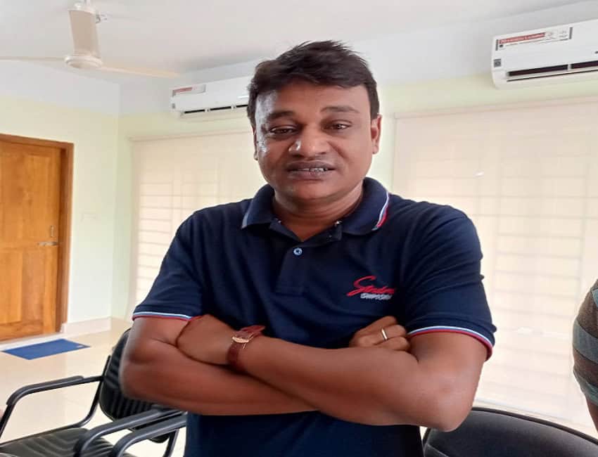অফিসে একজন ব্যক্তি, হাত ক্রস করে দাঁড়িয়ে আছেন. Channel i News - চ্যানেল আই নিউজ