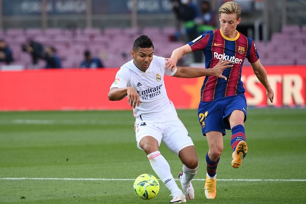 Real Madrid's Brazilian midfielder Casemiro (L) challenges Barcelona's Dutch midfielder Frenkie De Jong during the Spanish League football match between Barcelona and Real Madrid at the Camp Nou stadium in Barcelona on October 24, 2020. (Photo by LLUIS GENE / AFP) (Photo by LLUIS GENE/AFP via Getty Images)