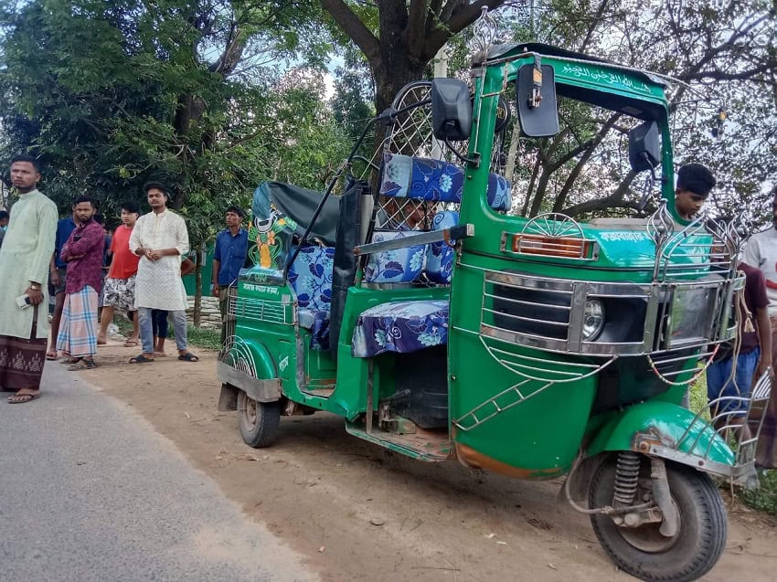 রিকশা ট্রাইসাইকেল রাস্তার পাশে দাঁড়িয়ে, কিছু মানুষ আশেপাশে. Channel i News - চ্যানেল আই নিউজ