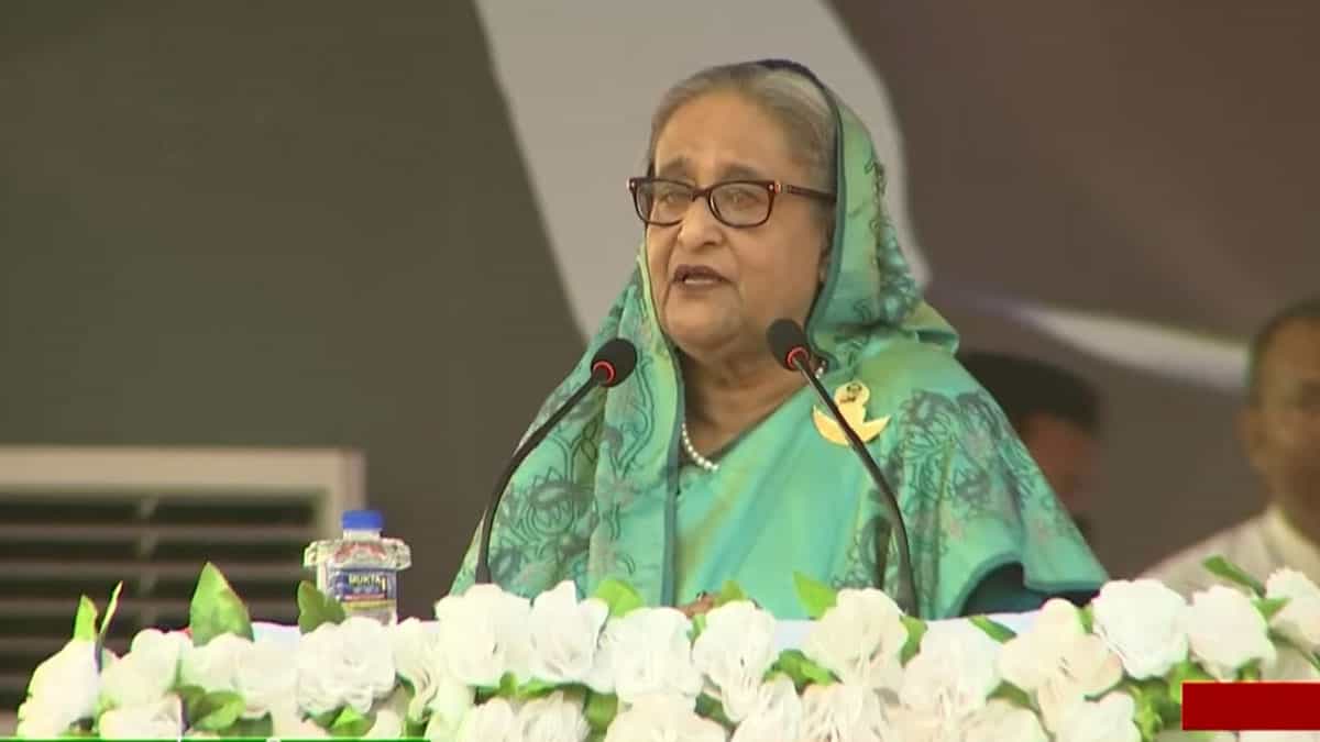 প্রধানমন্ত্রী শেখ হাসিনা জনসভায় ভাষণ দিচ্ছেন, পেছনে অন্য নেতারা উপস্থিত. Channel i News - চ্যানেল আই নিউজ