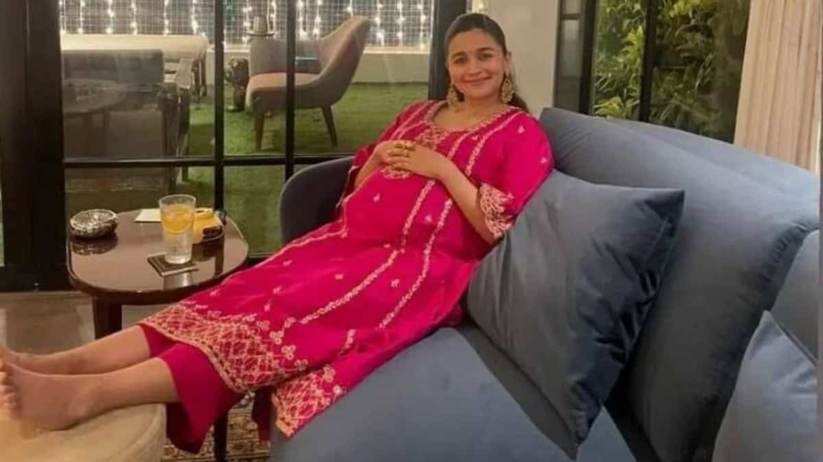 আলিয়া হাস্যোজ্জ্বলভাবে বসে আছেন, সুন্দর পোশাক পরা. Channel i News - চ্যানেল আই নিউজ