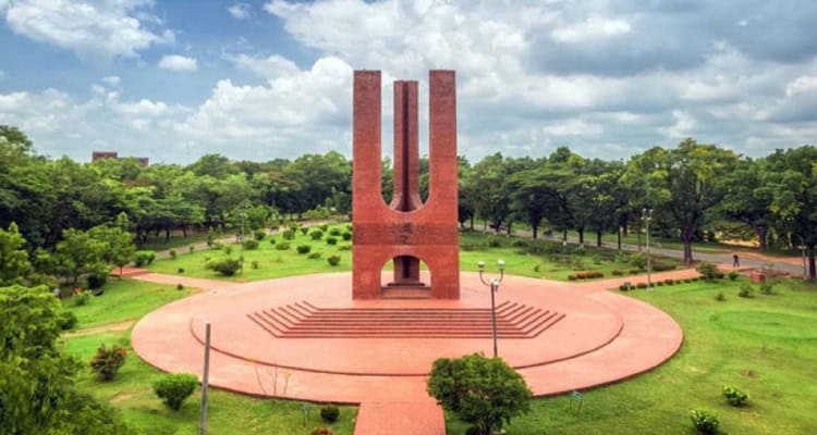 জাহাঙ্গীরনগর বিশ্ববিদ্যালয় এর স্মৃতিস্তম্ভের ছবি, সবুজ গাছপালা ও আকাশের পটভূমিতে. Channel i News - চ্যানেল আই নিউজ