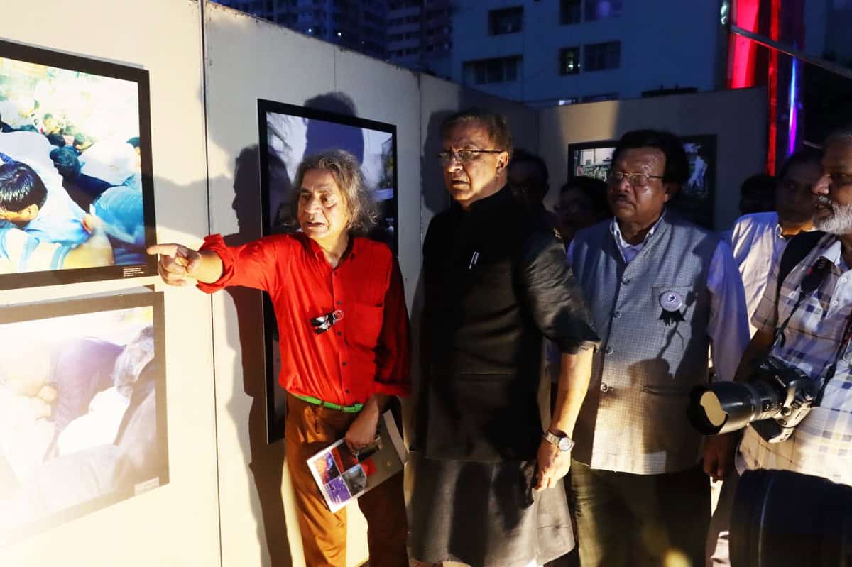 প্রদর্শনীতে দর্শকরা ছবি দেখছেন ও আলোচনা করছেন. Channel i News - চ্যানেল আই নিউজ
