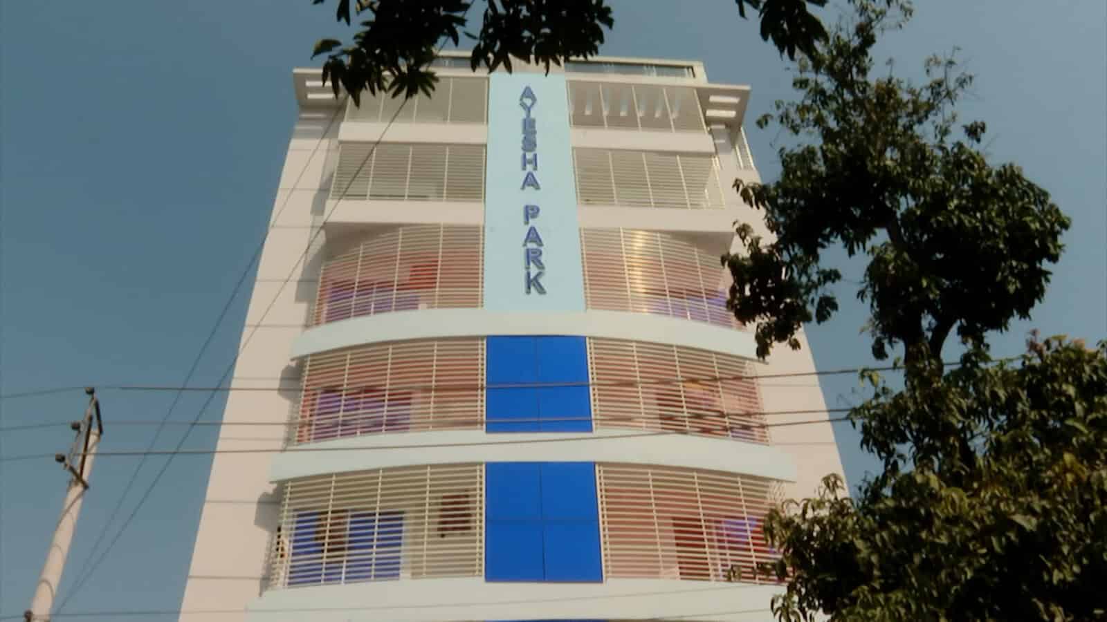 কোটা পার্ক ভবনের সামনে গাছের ছায়া ও বিদ্যুতের খুঁটি দেখা যাচ্ছে. Channel i News - চ্যানেল আই নিউজ