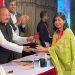 পুরস্কার গ্রহণ করছেন একজন তরুণ নারী ও পুরস্কার প্রদানকারী ব্যক্তি. Channel i News - চ্যানেল আই নিউজ