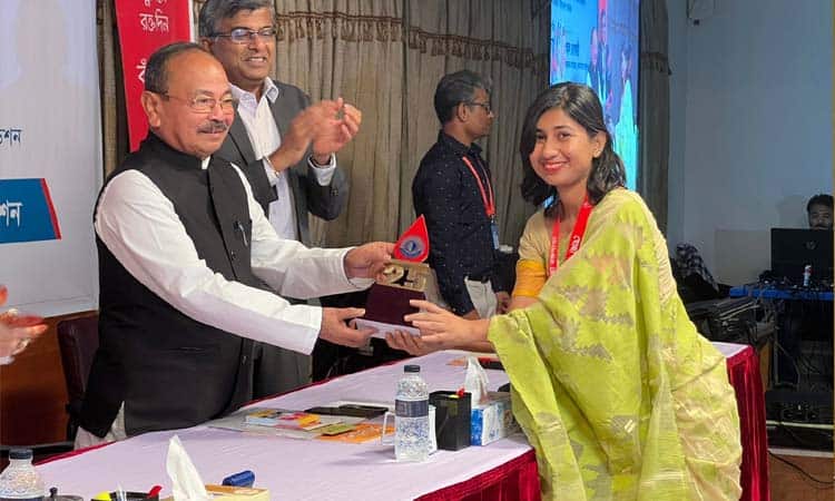 পুরস্কার গ্রহণ করছেন একজন তরুণ নারী ও পুরস্কার প্রদানকারী ব্যক্তি. Channel i News - চ্যানেল আই নিউজ