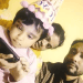 Child celebrating birthday with family, wearing party hat and looking at phone. Channel i News - চ্যানেল আই নিউজ