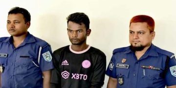 অভিযুক্ত যুবককে পুলিশ সদস্যদের সঙ্গে দেখা যাচ্ছে. Channel i News - চ্যানেল আই নিউজ