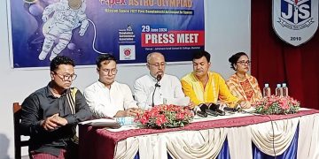 প্রেস কনফারেন্সে অংশগ্রহণকারী ব্যক্তিরা বসে আছেন, পেছনে অ্যাস্ট্রো-অলিম্পিয়াডের ব্যানার।. Channel i News - চ্যানেল আই নিউজ