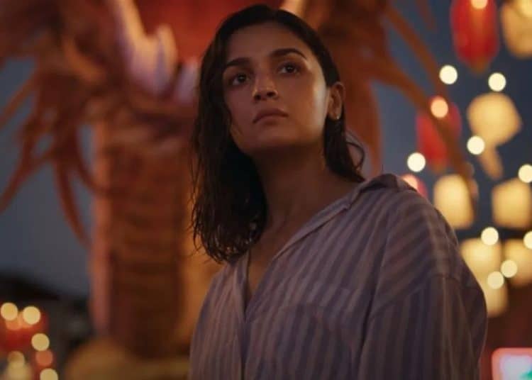 আলিয়া ভাটের ছবি, তিনি একা বসে আছেন, পেছনে আলো ঝলমল করছে।. Channel i News - চ্যানেল আই নিউজ
