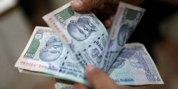FILE PHOTO: An employee counts Indian rupee currency notes inside a private money exchange office in New Delhi July 5, 2013.  REUTERS/Adnan Abidi/File Photo