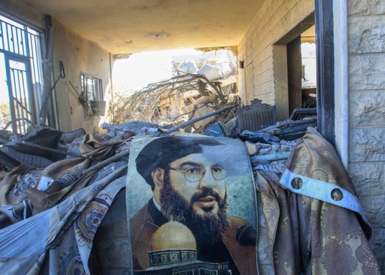 TOPSHOT - A portrait of Hezbollah chief Hassan Nasrallah sits amid destruction in a area targeted overnight by Israeli airstrikes in Saksakiyeh on September 26, 2024. Israel flatly rejected on September 26 a push led by key backer the United States for a 21-day ceasefire in Lebanon, as it vowed to keep fighting Hezbollah militants "until victory". (Photo by Mahmoud ZAYYAT / AFP) (Photo by MAHMOUD ZAYYAT/AFP via Getty Images)