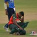 Bangladeshi cricketer sitting on the field with helmet and gear. Channel i News - চ্যানেল আই নিউজ