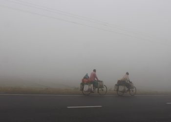 ঘন কুয়াশায় ঢাকা রাস্তা, দুইজন বাইসাইকেল চালক ও পথচারী. Channel i News - চ্যানেল আই নিউজ