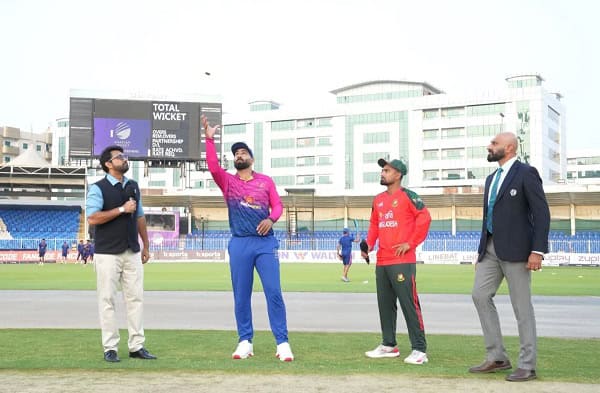 বাংলাদেশের ক্রিকেটাররা মাঠে প্রস্তুত, একজন বল হাতে, অন্যরা আলোচনা করছে. Channel i News - চ্যানেল আই নিউজ
