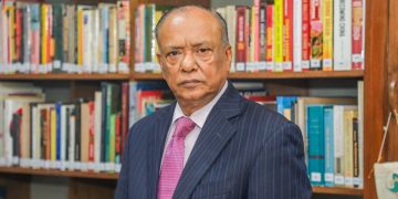 আবদুল আউয়াল মিন্টু বইয়ের সামনে দাঁড়িয়ে ছবি তোলা. Channel i News - চ্যানেল আই নিউজ