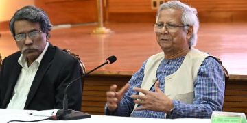 প্রধান উপদেষ্টার সাথে আলোচনা করছেন একজন ব্যক্তি, পেছনে বাংলার পতাকা. Channel i News - চ্যানেল আই নিউজ