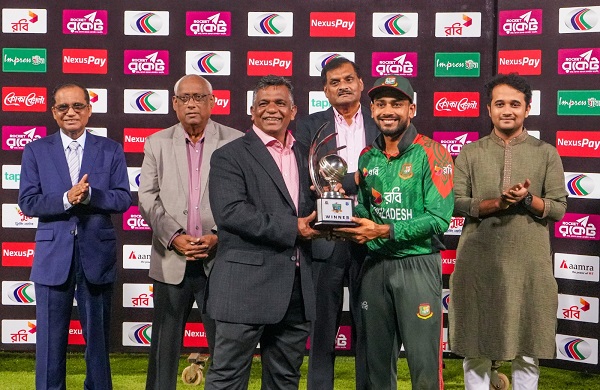 বিসিবি সভাপতি আমিনুল ইসলামের হাত থেকে ট্রফি নিচ্ছেন মেহেদী হাসান মিরাজ। ছবি: বিসিবি