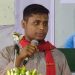 ছাত্র বক্তা বক্তৃতা দিচ্ছে, পেছনে ছবি ও মাইক ধরা ছাত্র. Channel i News - চ্যানেল আই নিউজ