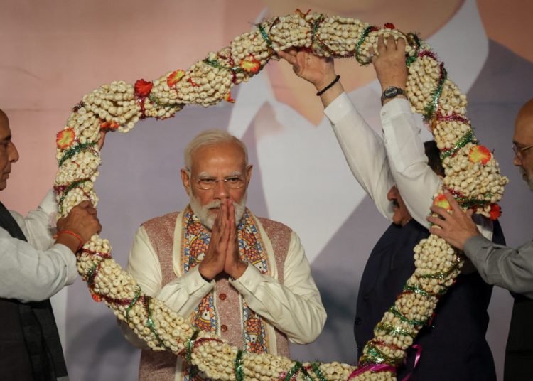 India's Home Minister Amit Shah and India's Defence Minister Rajnath Singh present a garland to Prime Minister Narendra Modi, as Bharatiya Janata Party (BJP) supporters celebrate the Bihar state assembly election results, at the party headquarters in New Delhi, India, November 14, 2025. REUTERS/Adnan Abidi