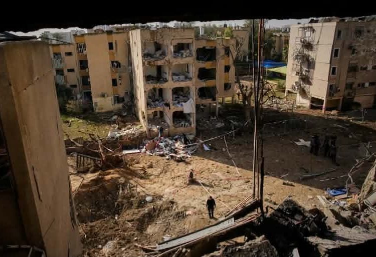 ফিচারড ইমেজ ক্যাপশন: দক্ষিণ ইসরায়েলের আরাদ শহরে ইরানি ক্ষেপণাস্ত্র হামলায় বিধ্বস্ত আবাসিক ভবন দেখছেন স্থানীয়রা, ২২ মার্চ ২০২৬।