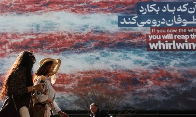 তেহরানে যুক্তরাষ্ট্রবিরোধী একটি বিলবোর্ডের পাশ দিয়ে হেঁটে যাচ্ছেন কিছু মানুষ